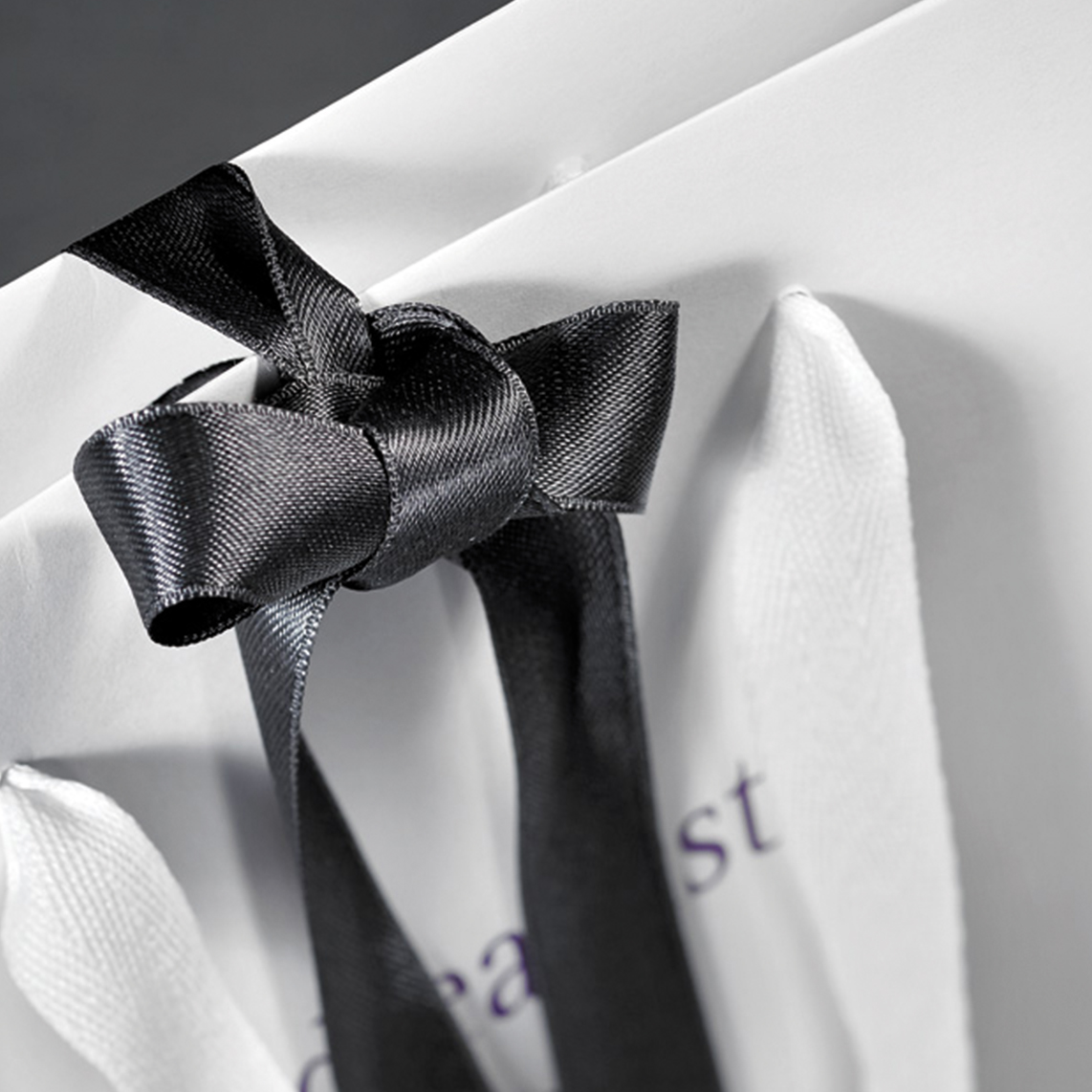 Papiertragetaschendetail mit Trage-Bändern und Geschenkschleife